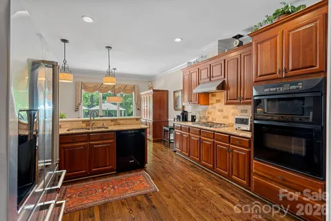 a kitchen with stainless steel appliances granite countertop a stove a sink and a refrigerator