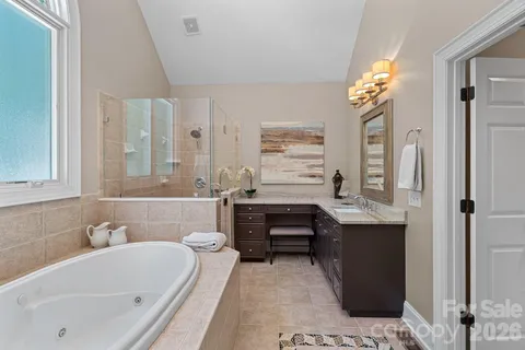 a bathroom with a tub sink and mirror