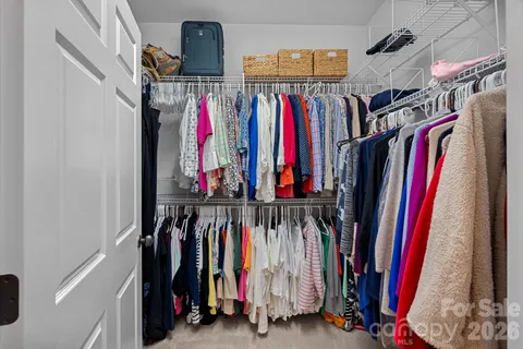 a view of walk in closet with clothes
