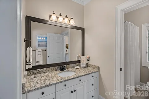 a bathroom with a granite countertop sink and a mirror