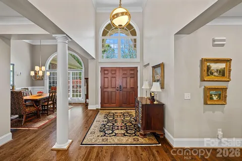 a view of a hallway with wooden floor and a dining table