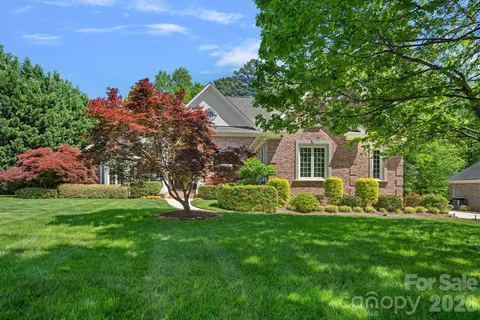 a front view of a house with garden and trees