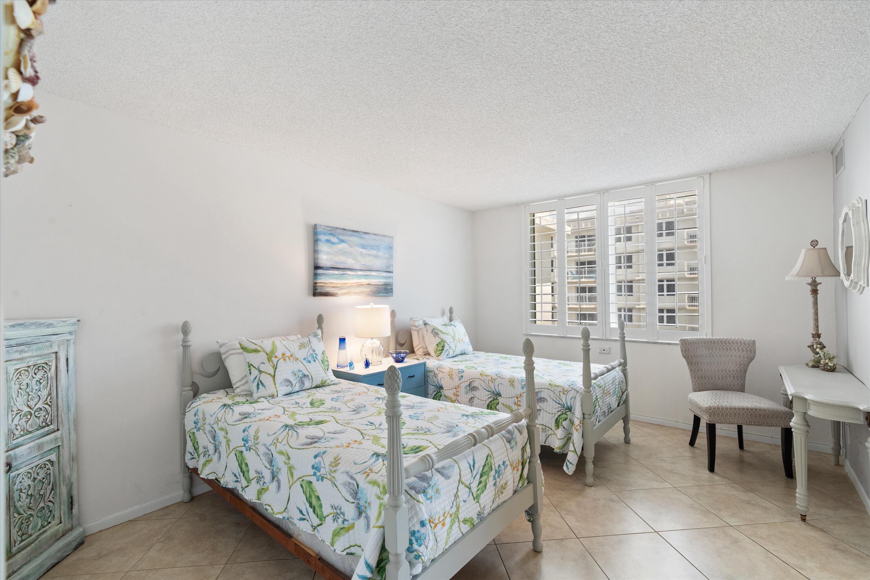 3301 South Ocean Boulevard, Unit 808 Highland Beach, FL 33487 - Photo 16 of 33 a bedroom with a bed a table and chair