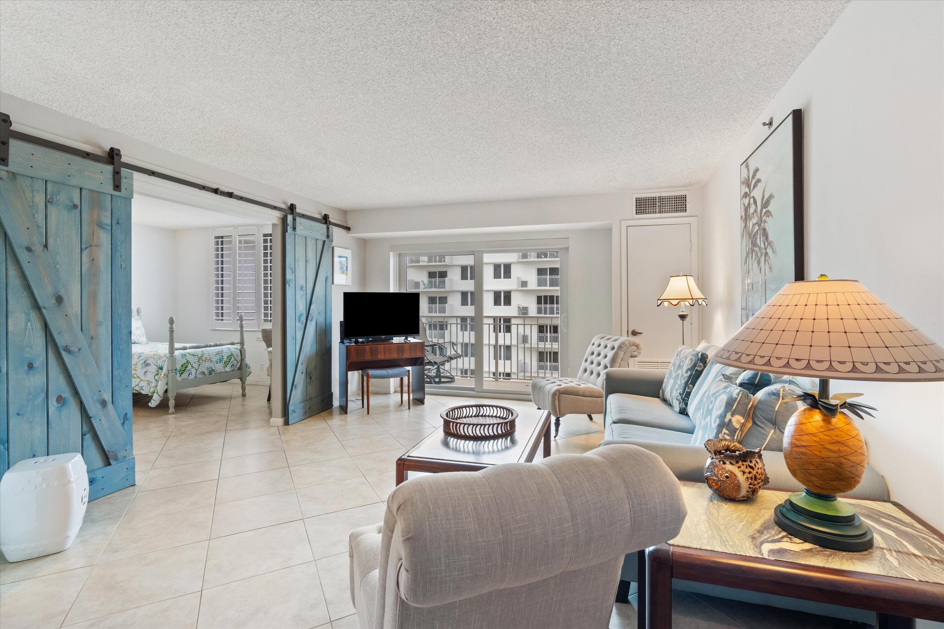 3301 South Ocean Boulevard, Unit 808 Highland Beach, FL 33487 - Photo 18 of 33 a living room with furniture a flat screen tv and a window