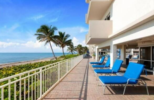 3301 South Ocean Boulevard, Unit 808 Highland Beach, FL 33487 - Photo 33 of 33 a view of a balcony with chairs and potted plants