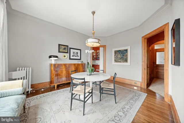 a dining room with furniture a chandelier and wooden floor
