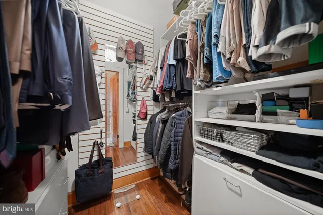a view of walk in closet with clothes and shoes