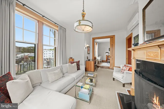 a living room with furniture a fireplace and a large window