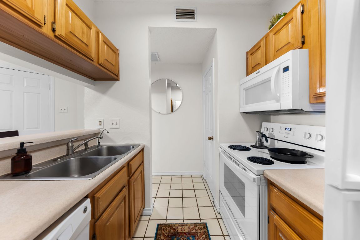 3001 Cedar Street, Unit 310 Austin, TX 78705 - Photo 13 of 27 a kitchen with stainless steel appliances a sink a stove and a microwave