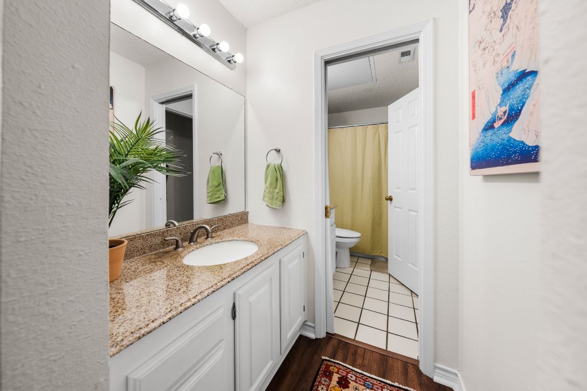 3001 Cedar Street, Unit 310 Austin, TX 78705 - Photo 20 of 27 a spacious bathroom with a granite countertop sink and a mirror