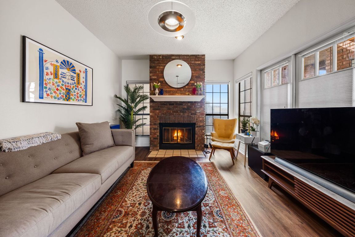 3001 Cedar Street, Unit 310 Austin, TX 78705 - Photo 2 of 27 a living room with furniture a flat screen tv and a fireplace