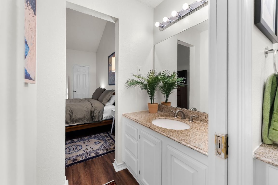 3001 Cedar Street, Unit 310 Austin, TX 78705 - Photo 21 of 27 a en suite bathroom with a granite countertop sink and a mirror