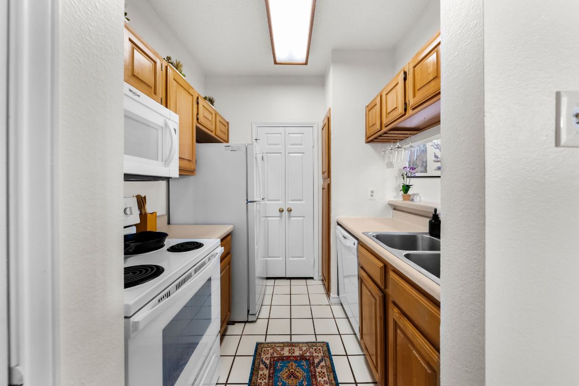 3001 Cedar Street, Unit 310 Austin, TX 78705 - Photo 10 of 27 a kitchen with a sink a stove and cabinets