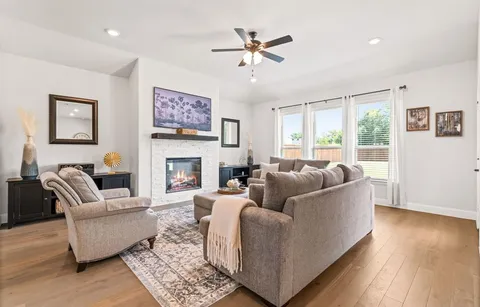 a living room with furniture a large window and a fireplace