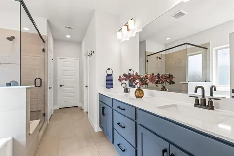 a spacious bathroom with a sink double vanity granite and a mirror