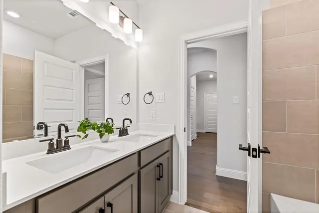a bathroom with a double vanity sink and mirror