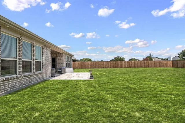 a view of a house with a yard and sitting area