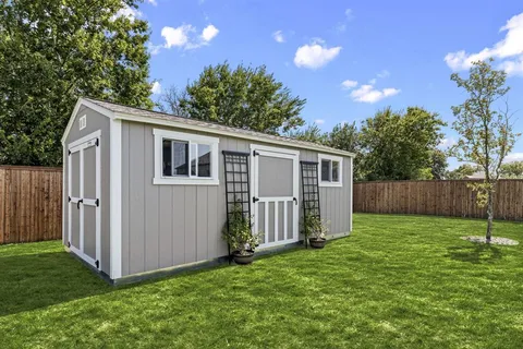 a view of a backyard with potted plants and wooden fence
