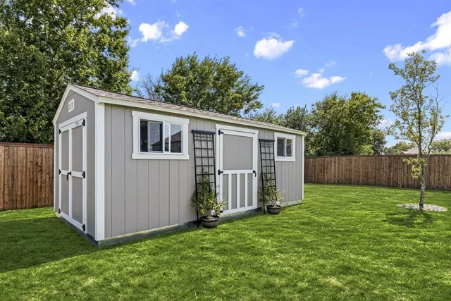 a view of a backyard with potted plants and wooden fence