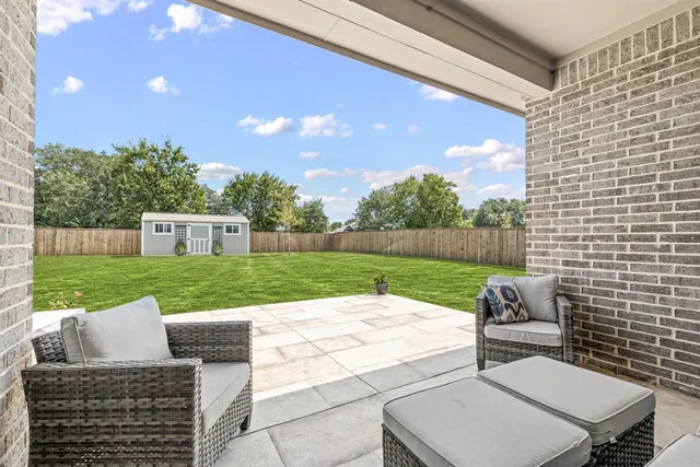 a view of a patio with a table chairs and a yard