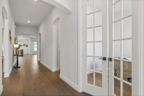 a view of a hallway with wooden floor and staircase