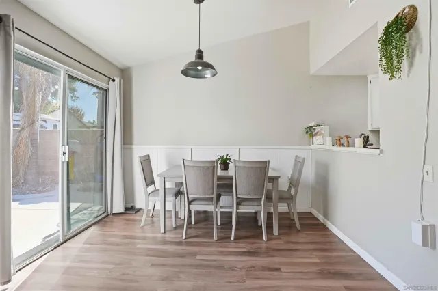 a dining room with wooden floor a chandelier a glass table and chairs