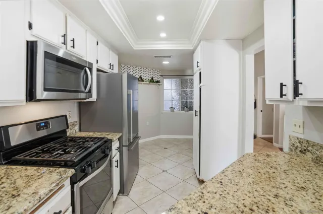 a kitchen with stainless steel appliances granite countertop a refrigerator and a stove top oven