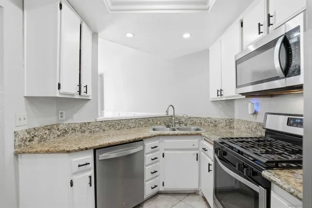 a kitchen with stainless steel appliances granite countertop a sink stove and microwave