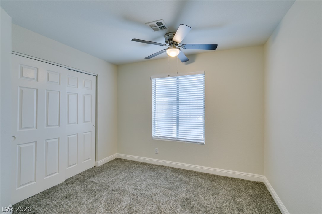 1738 Toltec Circle Henderson, NV 89014 - Photo 17 of 46 A comfortable bedroom with soft carpeting and a ceiling fan, offering a tranquil retreat.