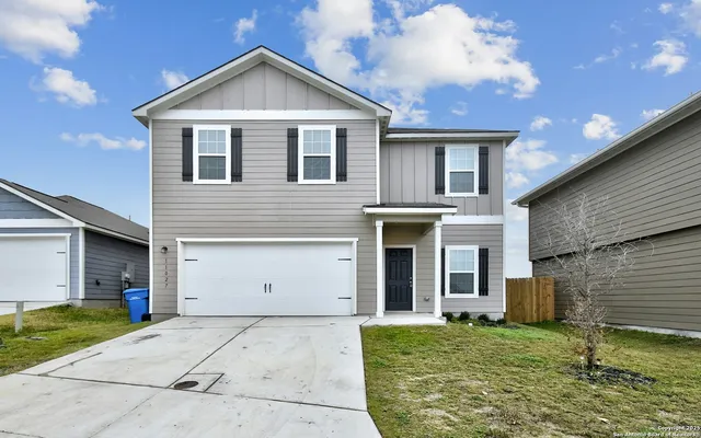 a view of a white house with a small yard and a large window