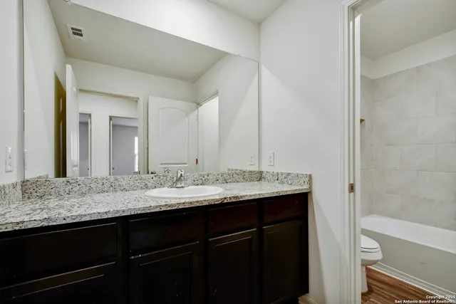 a bathroom with a granite countertop sink and a mirror