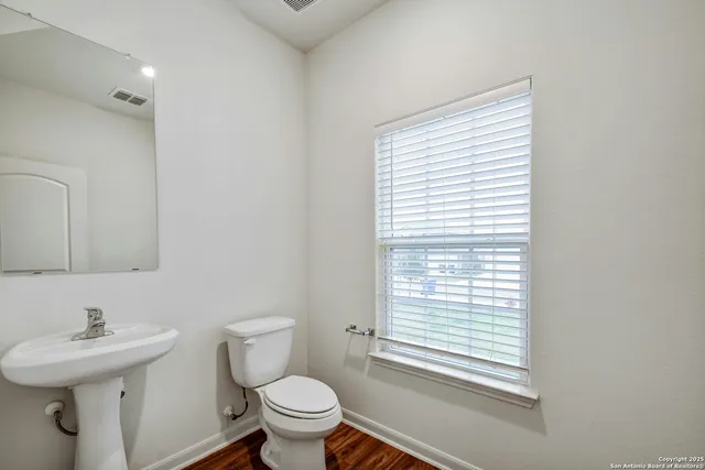 a bathroom with a sink a toilet and a window