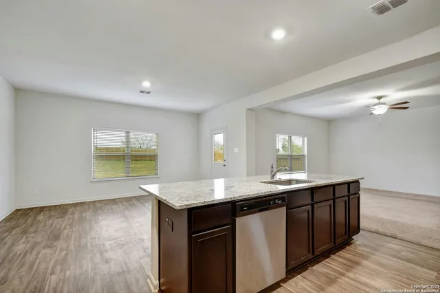 a kitchen with a sink cabinets and wooden floor