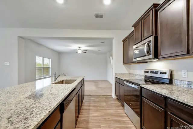 a kitchen with stainless steel appliances granite countertop a sink and stove