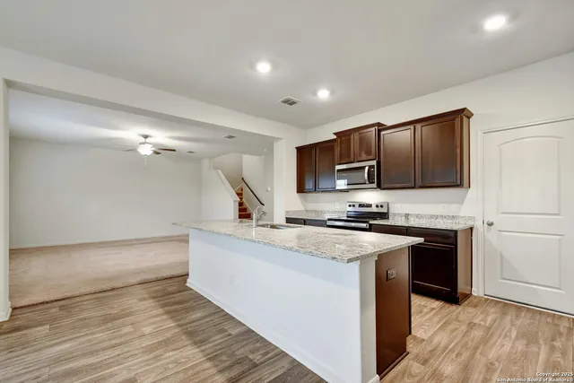 a kitchen with stainless steel appliances granite countertop a stove a sink and a refrigerator