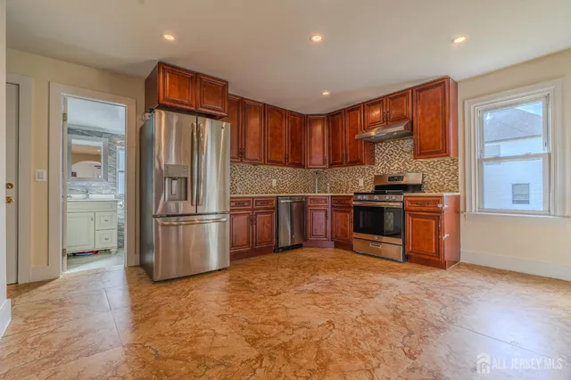 a kitchen with stainless steel appliances granite countertop a stove a sink and a refrigerator
