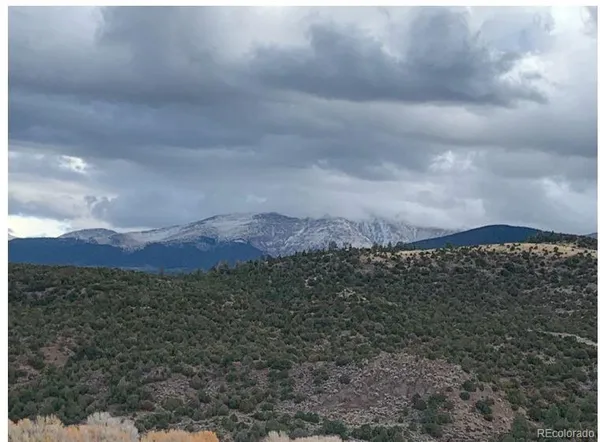 a view of a dry yard with mountains in the background
