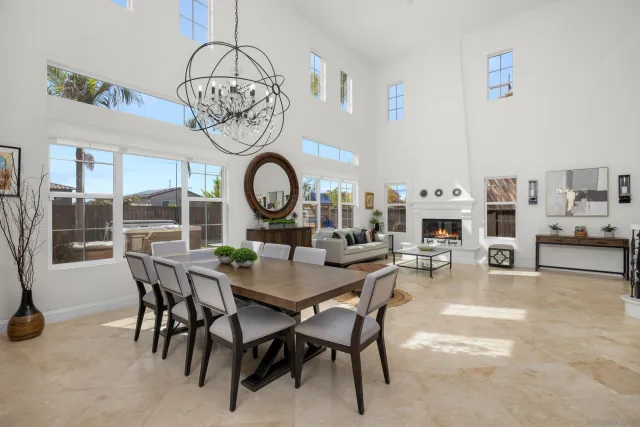 a view of a dining room and livingroom with furniture a rug a fireplace and a chandelier