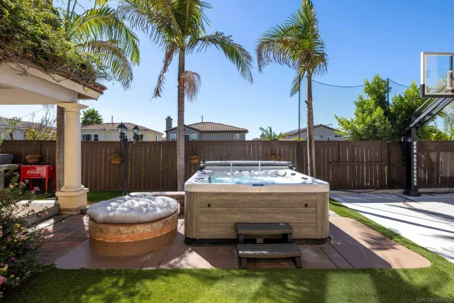 a view of a backyard with table and chairs potted plants and palm tree