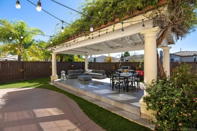 a view of a patio with table and chairs potted plants and a large tree