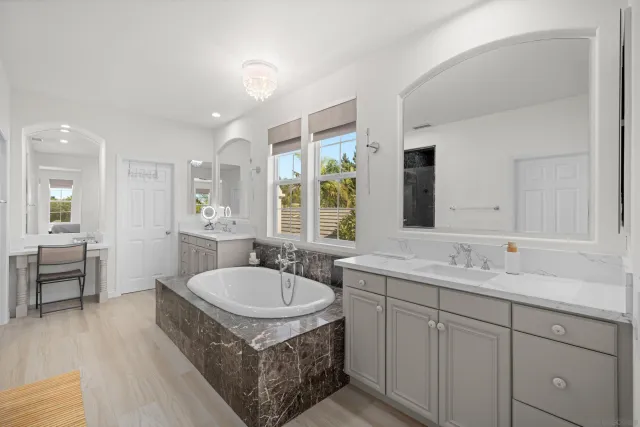 a spacious bathroom with a granite countertop tub sink and mirror