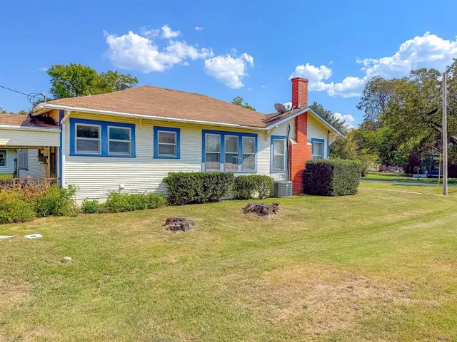 a view of a house with a yard and potted plants