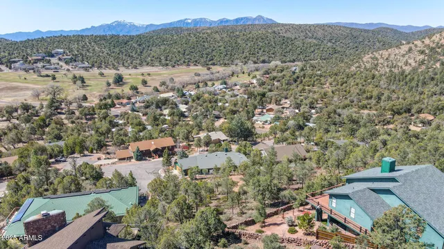 an aerial view of a city with lots of residential buildings and mountain view in back