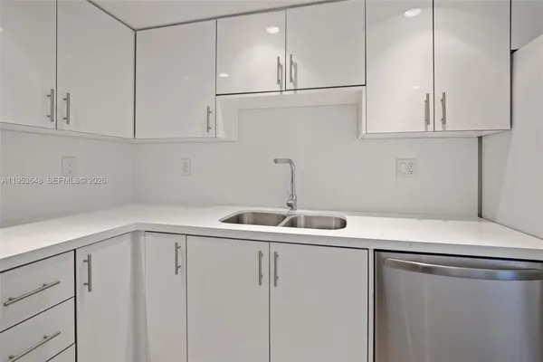 a kitchen with white cabinets and sink