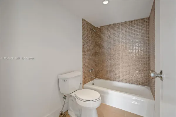 a bathroom with a granite countertop toilet a sink and bathtub