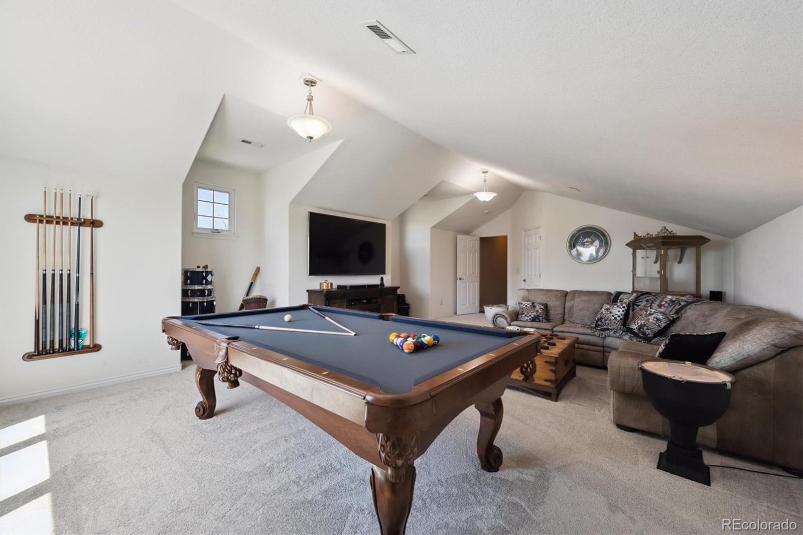 724 Imboden Road Watkins, CO 80137 - Photo 30 of 50 a living room with furniture a flat screen tv and a table