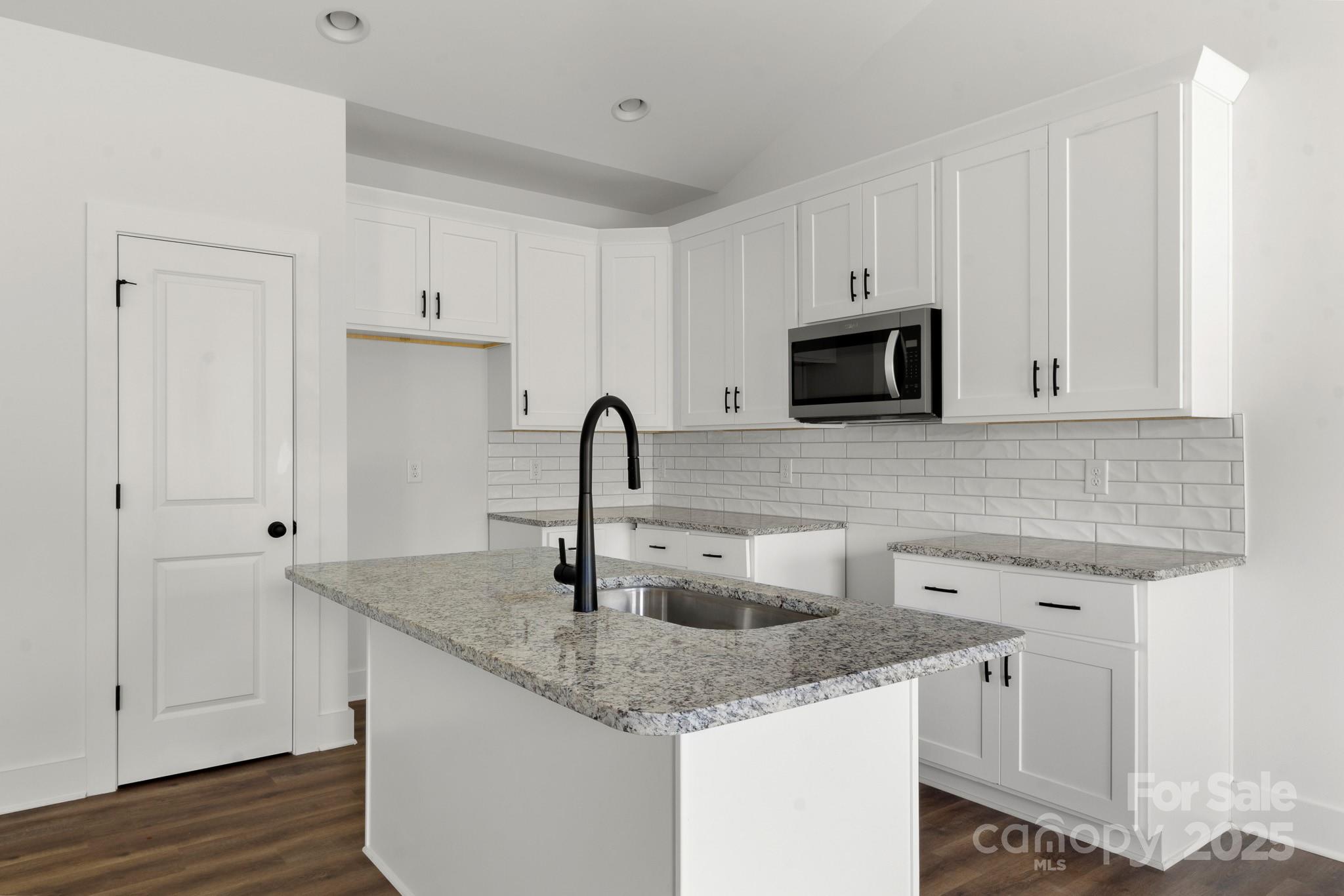 2508 Rock Dam Road Harmony, NC 28634 - Photo 12 of 32 a kitchen with stainless steel appliances granite countertop a sink stove and microwave