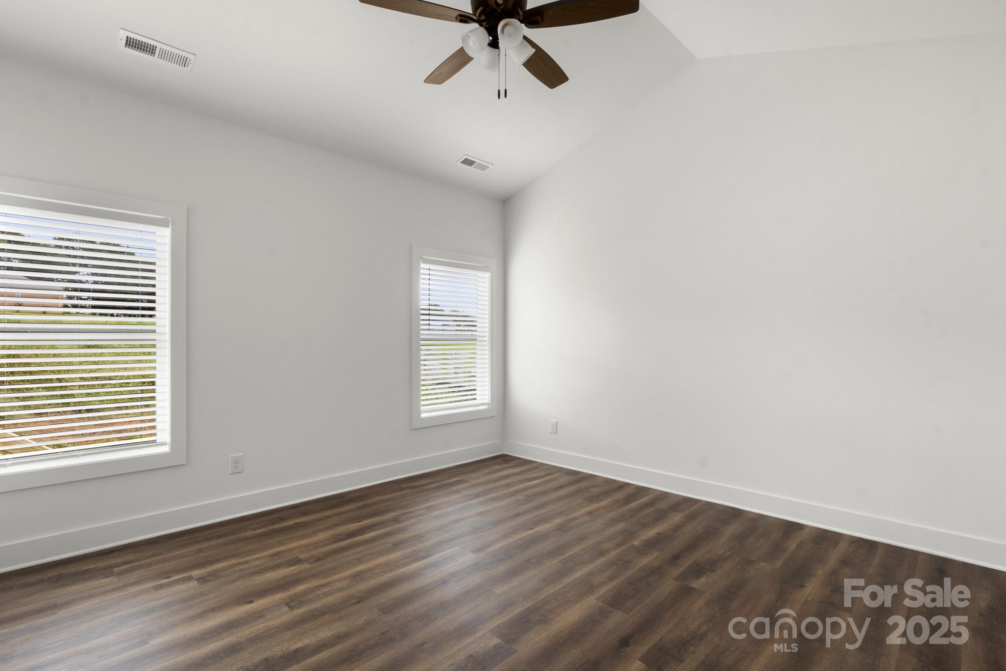 2508 Rock Dam Road Harmony, NC 28634 - Photo 15 of 32 an empty room with wooden floor chandelier fan and windows
