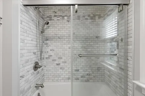 a bathroom with a shower and a bath tub