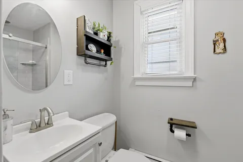 a bathroom with a toilet sink and mirror